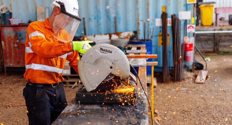 Work using a mitre saw with protective helmet and face cover