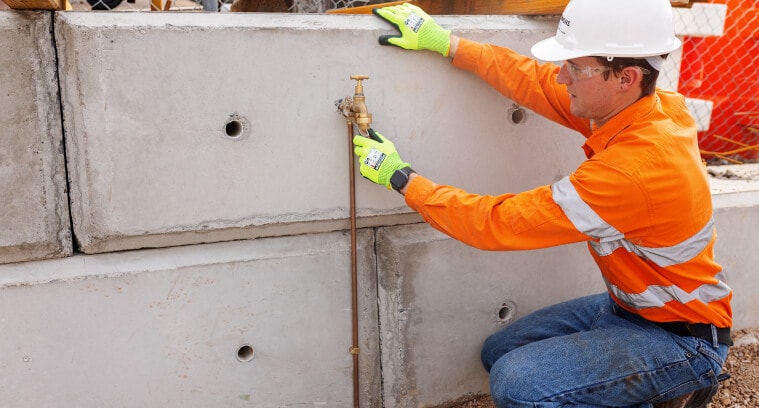 Worker installing plumbing line and tap