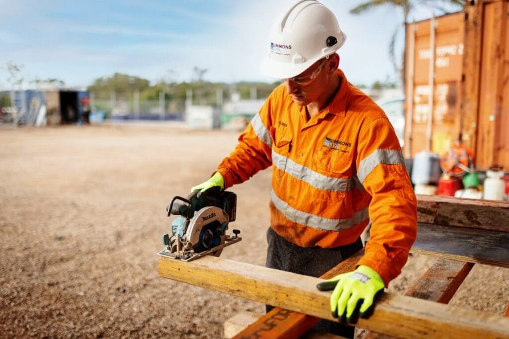 Simmons Civil worker cutting timber with circular saw