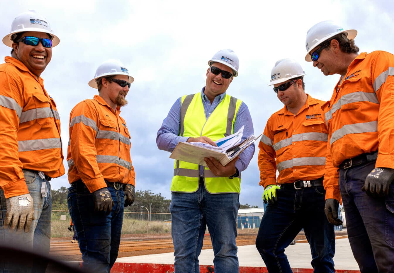 5 Simmons Civil workers smiling during an on-site meeting