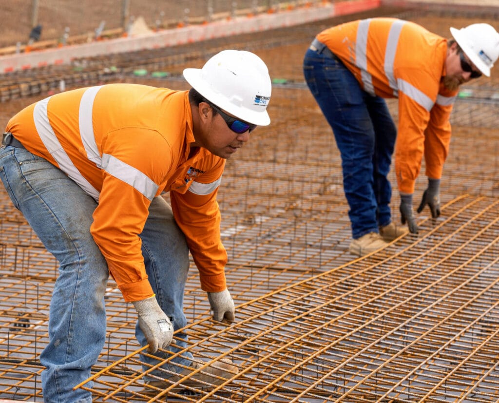 Two Simmons Civils workers moving galvanised mesh in to place